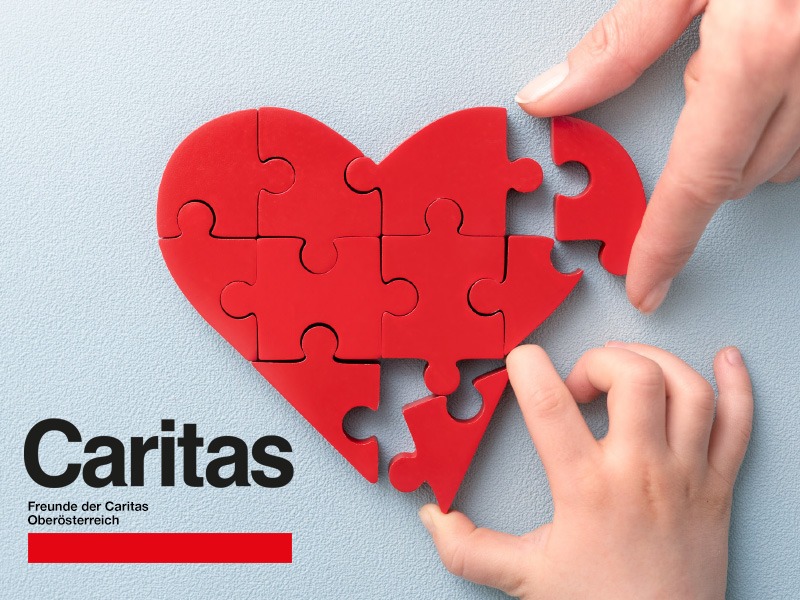 Eine Erwachsenen - u. eine Kinderhand fügen ein herzförmiges Puzzle zusammen.