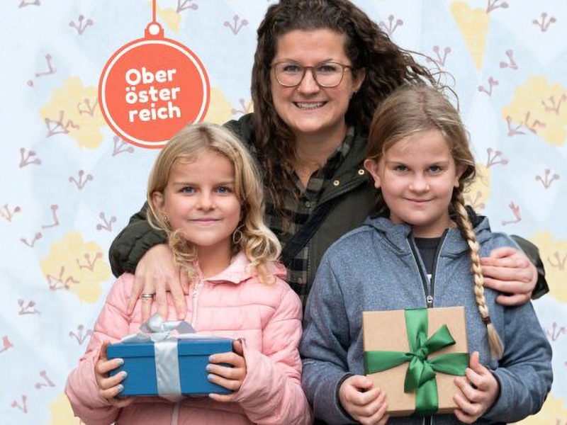 Eine Frau mit zwei Mädchen, die Geschenke in ihren Händen halten